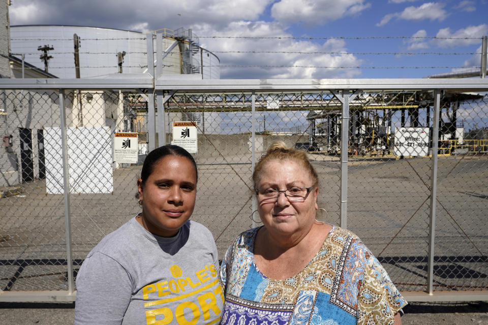 Monica Huertas, left, and Linda Perri, right, both of Providence, R.I., stand for a photograph in a neighborhood in Providence that features industrial businesses, Thursday, Aug. 18, 2022. In Rhode Island, state lawmakers considered a bill this year to exempt such facilities from solid waste licensing requirements. (AP Photo/Steven Senne)