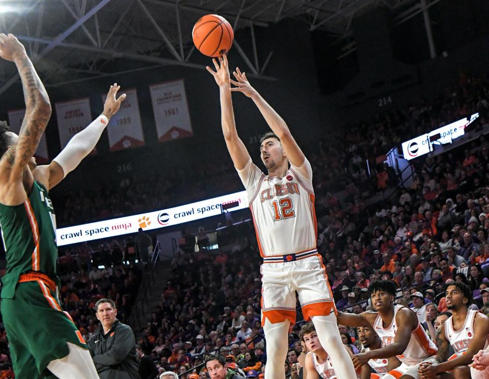 Clemson senior guard Alex Hemenway (12) makes a three-point shot near Miami guard Jordan Miller (11) during the second half at Littlejohn Coliseum in Clemson, S.C. Saturday, Feb. 4, 2023.