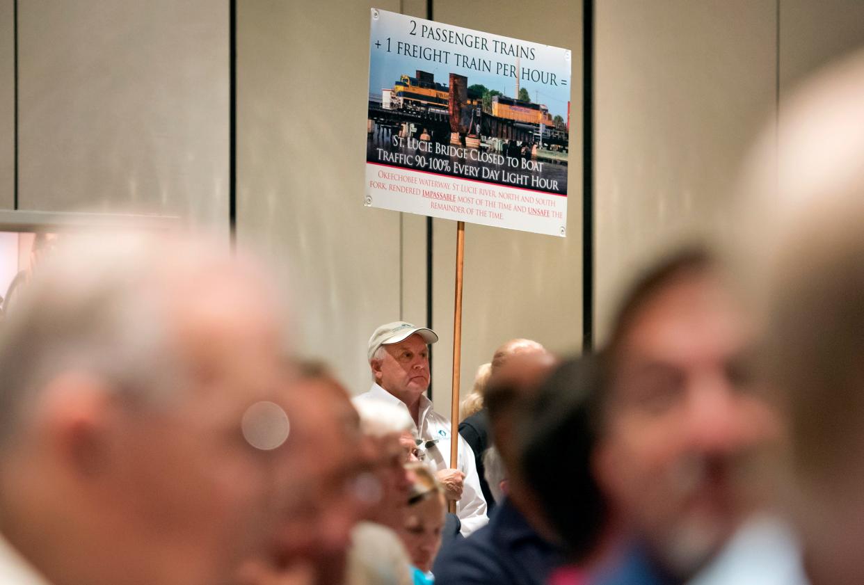 Peter Schmidt of Stuart, holds a sign opposing All Aboard Florida while attending the Coast Guard meeting on navigation at the Blake Library Nov. 13, 2014. An overflow crowd, with most speaking in opposition to the high-speed passenger trains, filled the library for the second of three meetings being held by the Coast Guard.