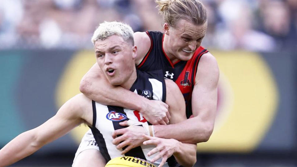 Seen here, Collingwood's Jack Ginnivan is taken by the neck in a tackle from Essendon's Mason Redman.