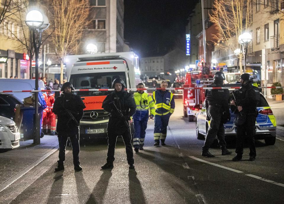 Police guard the scenery in front of a restaurant in central Hanau, Germany Thursday, Feb. 20, 2020. German police say several people were shot to death in the city of Hanau on Wednesday evening. (AP Photo/Michael Probst)