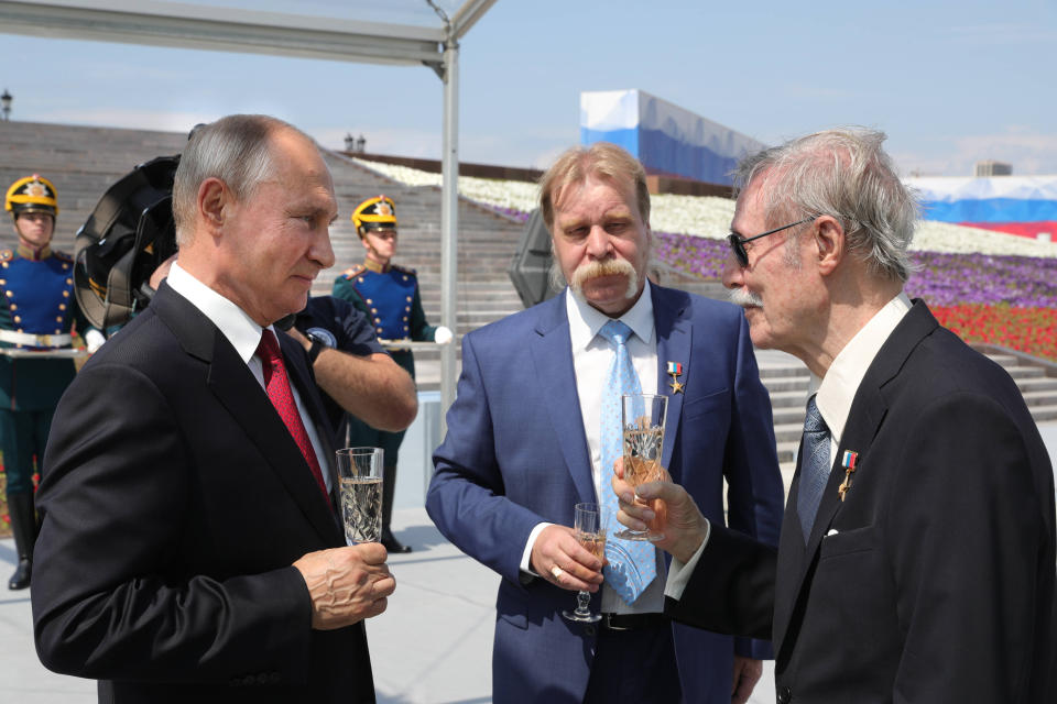 Russian President Vladimir Putin, left, speaks with Yury Solomin, artistic director of the State Academic Maly theater, right, during a ceremony of handing Gold Stars medals to heroes of labor marking the Day of Russia holiday in Moscow, Russia, on Friday, June 12, 2020. The ceremony marked the first big public event Putin attended since announcing a nationwide lockdown more than two months ago. (Mikhail Klimentyev, Sputnik, Kremlin Pool Photo via AP)