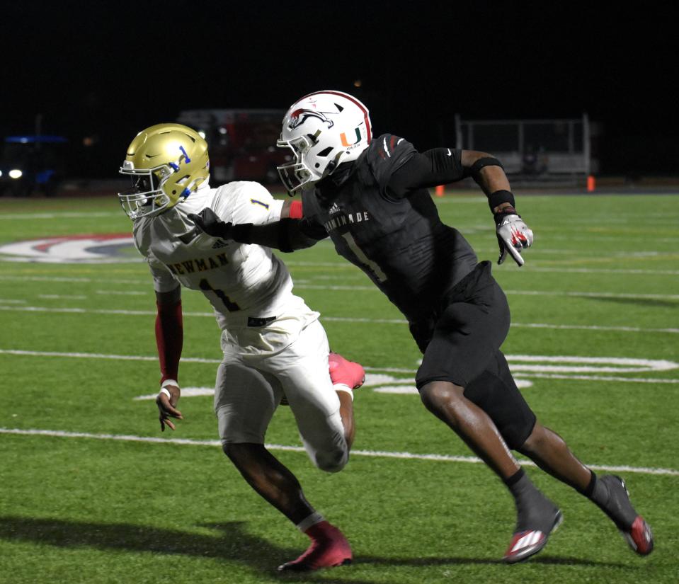 Cardinal Newman's Kevin Levy grapples with a Chaminade-Madonna receiver during a route in the regional finals game on Nov. 24, 2023.