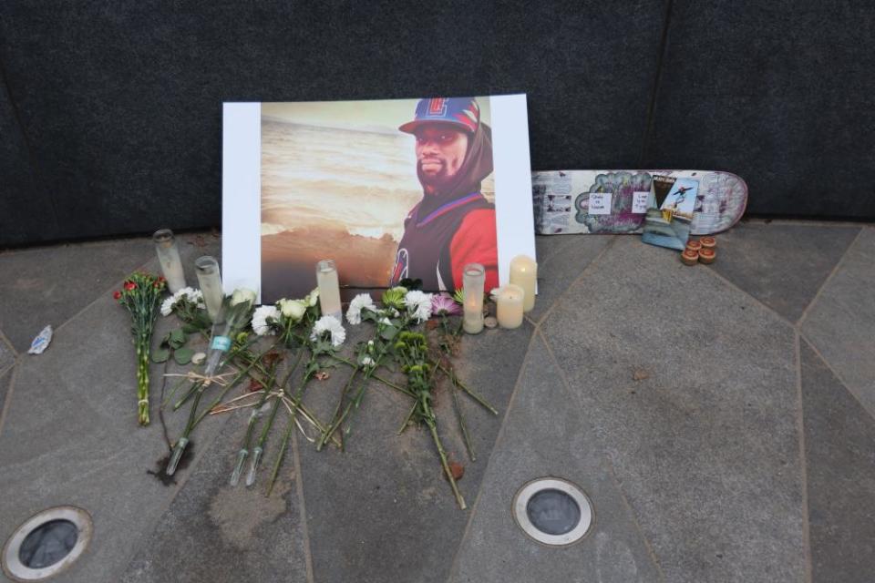 flowers next to portrait of nichols and skateboard that says 'skate in heaven'