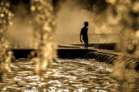 A man a public fountain before sunset in Bucharest, Romania, Thursday, June 20, 2024 as temperatures exceeded 38 degrees Celsius (100.4 Fahrenheit). The national weather forecaster issued a orange warning for western and southern Romania where temperatures are expected to reach 38 degrees Celsius (100.4 Fahrenheit) in the coming days. (AP Photo/Vadim Ghirda)