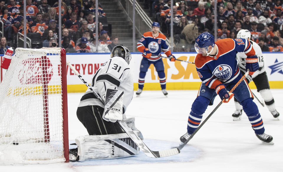 Edmonton Oilers' Zach Hyman (18) watches a tip-in by teammate Leon Draisaitl (not shown) go in past Los Angles Kings goalie David Rittich (31) during second-period NHL hockey game action in Edmonton, Alberta, Monday, Feb. 26, 2024. (Jason Franson/The Canadian Press via AP)