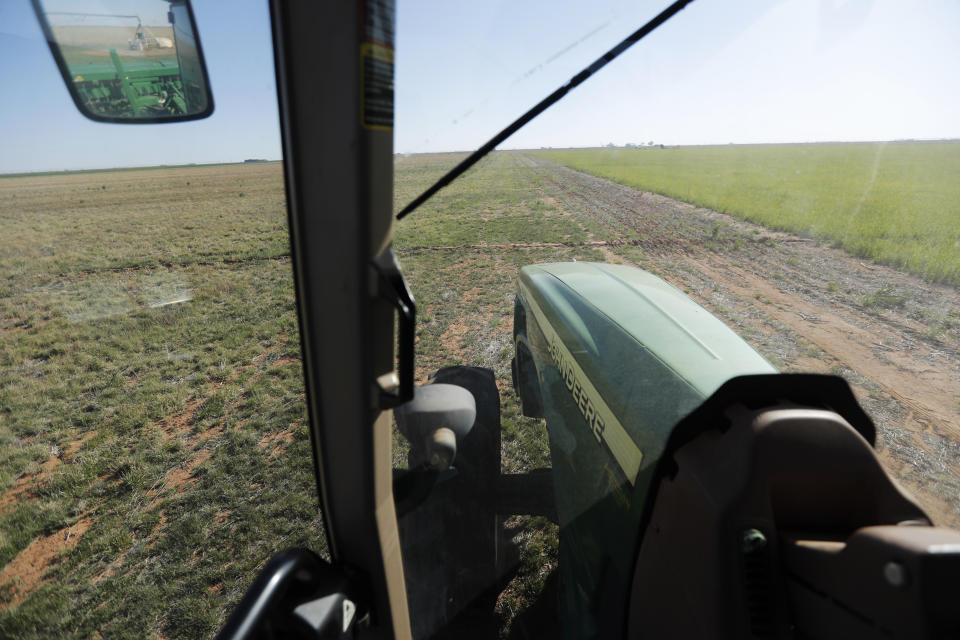 Tim Black uses his tractor's GPS system while planting grass seed on his Muleshoe, Texas, farm on Monday, April 19, 2021. The longtime corn farmer now raises cattle and plants some of his pasture in wheat and native grasses because the Ogallala Aquifer, needed to irrigate crops, is drying up. (AP Photo/Mark Rogers)