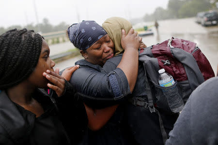 Residents embrace after being rescued from the flood waters of tropical storm Harvey in east Houston, Texas, U.S., August 28, 2017. REUTERS/Jonathan Bachman