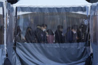 FILE - People queue in line to wait for the coronavirus testing at a makeshift testing site in Seoul, South Korea on Dec. 22, 2021. Caseloads of omicron have remained relatively low in many countries in Asia. For now, many remain insulated from the worst, although the next few months will remain critical. (AP Photo/Ahn Young-joon, File)