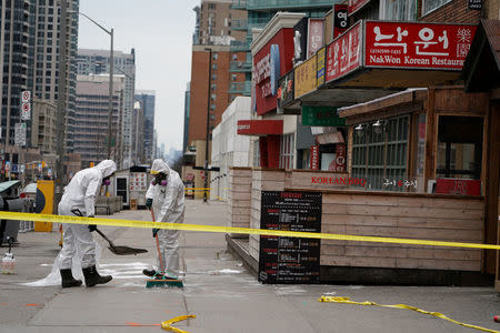 FILE PHOTO: Workers clean up blood stains on Yonge Street following a van that attacked multiple people in Toronto, Ontario, Canada, April 24, 2018. REUTERS/Carlo Allegri/File Photo
