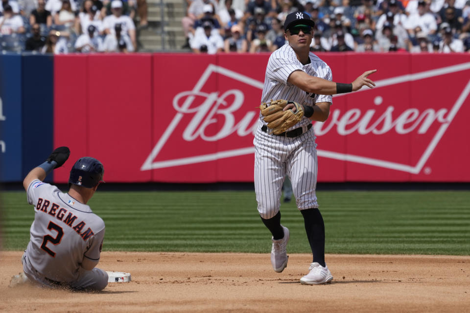New York Yankees shortstop Anthony Volpe, right, throws to first to complete a double play after forcing out Houston Astros' Alex Bregman (2) at second in the seventh inning of a baseball game, Saturday, Aug. 5, 2023, in New York. (AP Photo/Mary Altaffer)