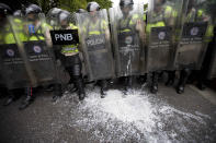 <p>White paint thrown by protesters covers the boots of Bolivarian National Police, who block an opposition march in Caracas, June 7, 2016. (AP/Ariana Cubillos) </p>