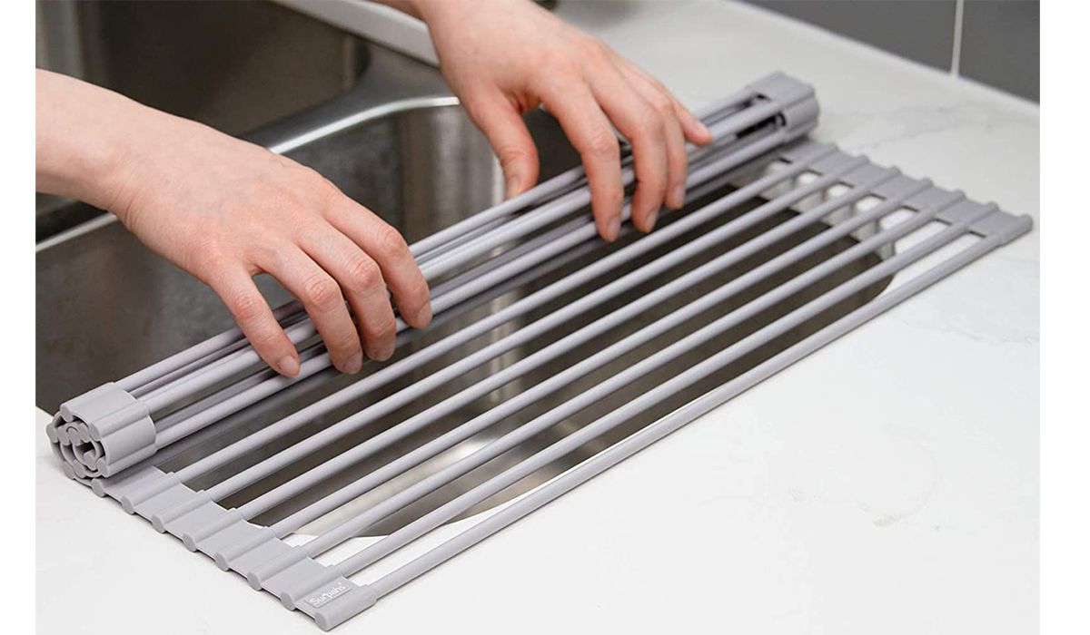 a person rolling up the rack over the sink