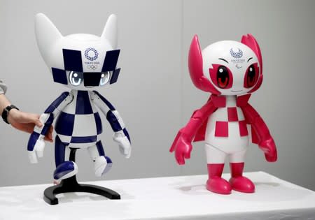 An employee of Toyota Motor Corp. displays Tokyo 2020 mascot robots Miraitowa and Someity which will be used to support the Tokyo 2020 Olympic and Paralympic Games, during a press preview in Tokyo