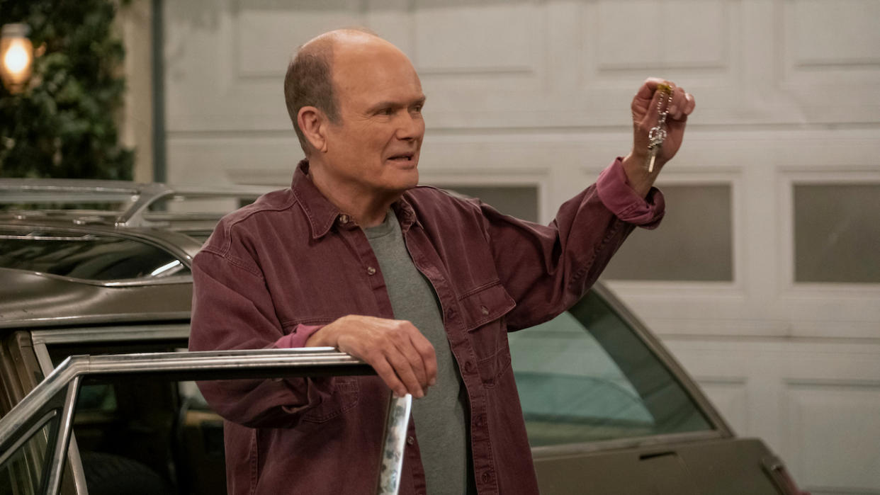  Red Forman holding up car keys while standing next to Vista Cruiser. 