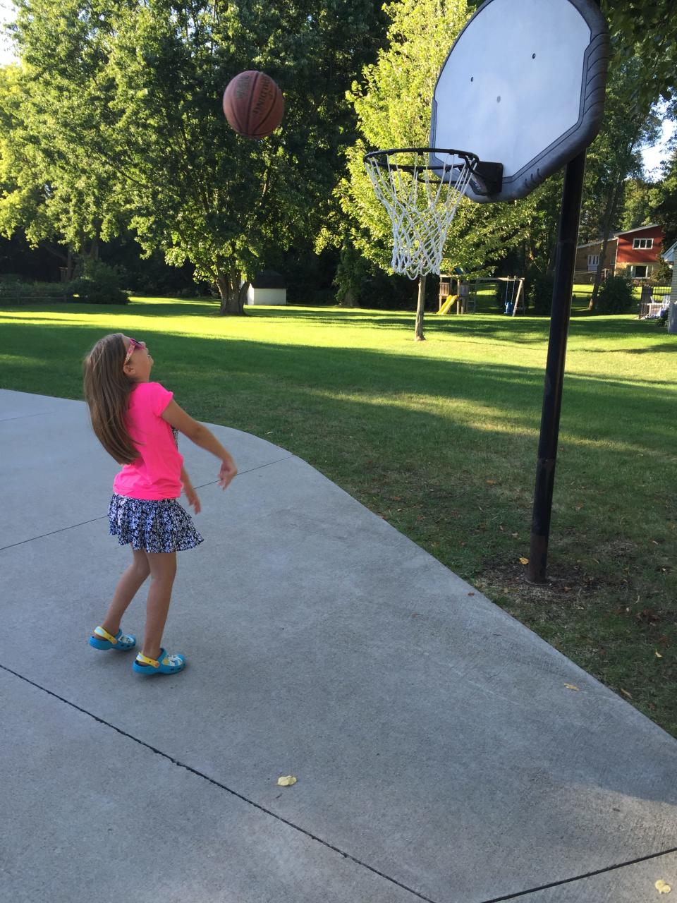 Keira Thompson, who wrote a children's book about her struggles learning to play basketball, practices making shots in her driveway in Brookfield.