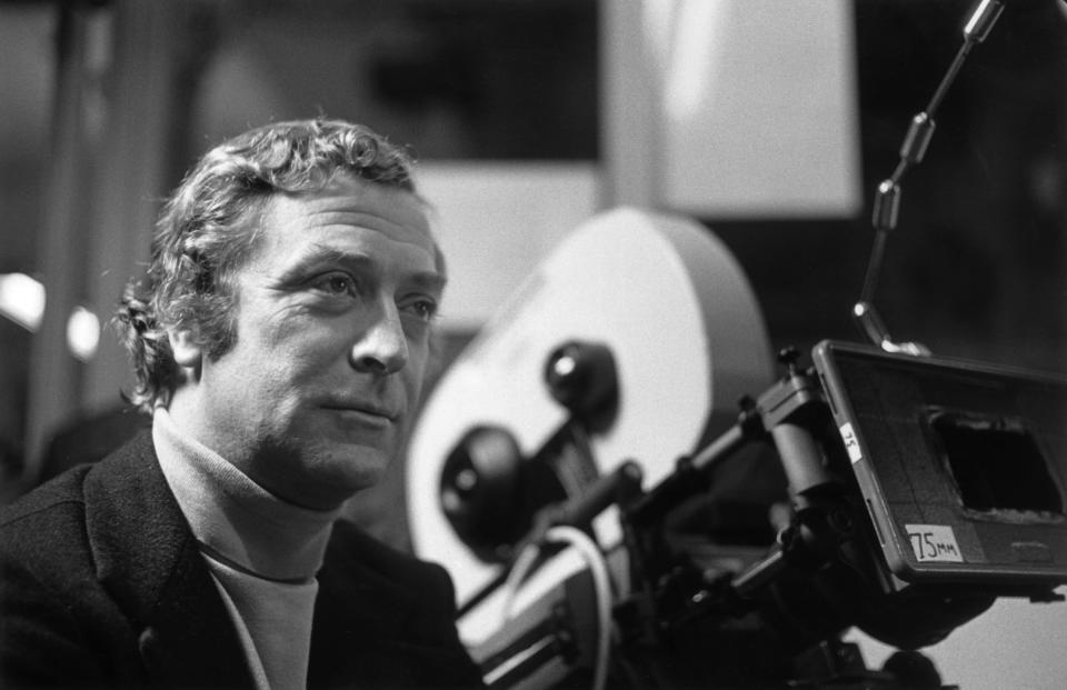 1980:  British actor Michael Caine stands next to a 75mm motion picture camera on the set of director Brian De Palma's film, 'Dressed to Kill'. Caine wears a turtleneck sweater and a blazer.  (Photo by Hulton Archive/Getty Images)