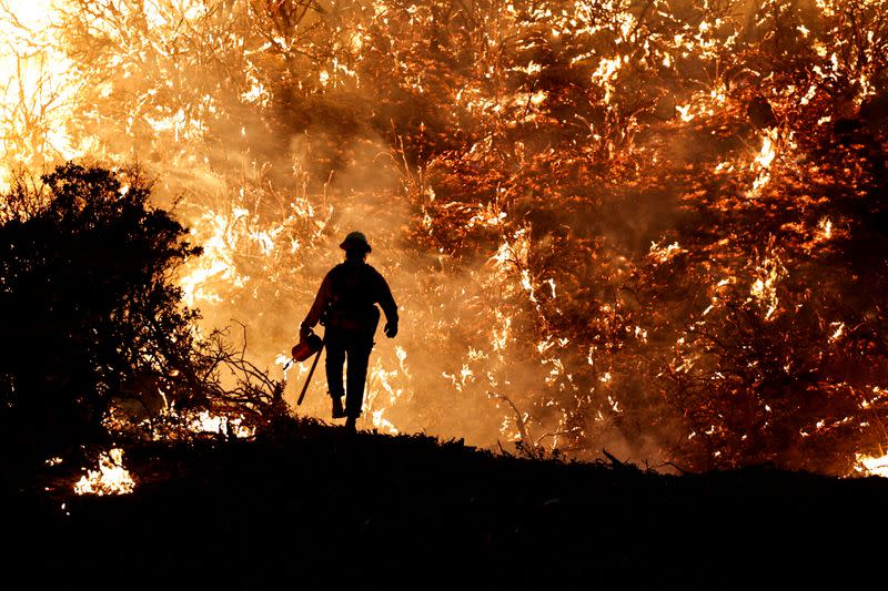 FILE PHOTO: A firefighter works as the Caldor Fire burns in Grizzly Flats