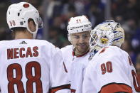 Carolina Hurricanes right wing Nino Niederreiter (21) and center Martin Necas (88) speak to Hurricanes emergency goalie David Ayres as he takes the ice against the Toronto Maple Leafs during second-period NHL hockey game action in Toronto, Saturday, Feb. 22, 2020. (Frank Gunn/The Canadian Press via AP)