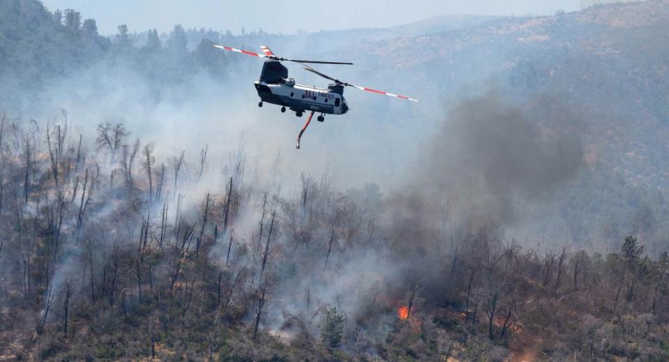 A helicopter flies over the Thompson Fire near the Oroville Dam on Wednesday.
