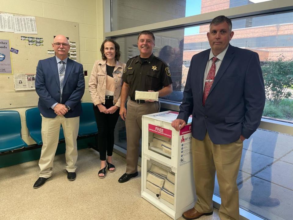 Calhoun County Sheriff's Office Chief Deputy David Tendziegloski, Substance Abuse Council Executive Director Dawn Smith, Sheriff Steve Hinkley, and sheriff's office Capt. Tracey Chambers showcase the new Narcan dispensing box installed inside the bond office of the jail.