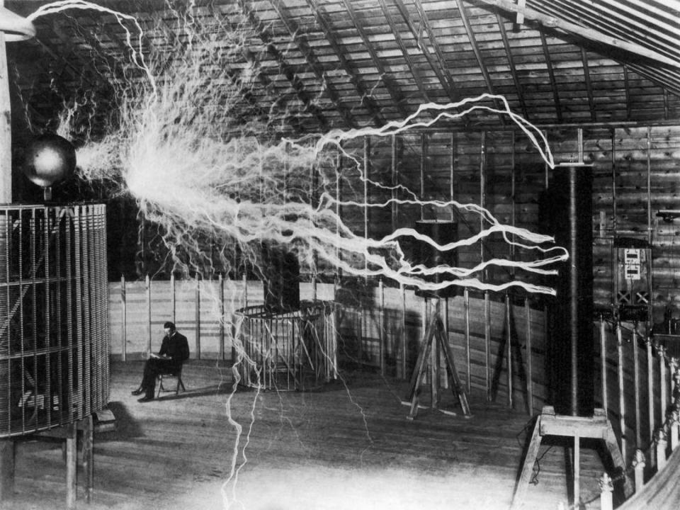 1899年12月，特斯拉在自己的實驗室，與」放大發射器「合影