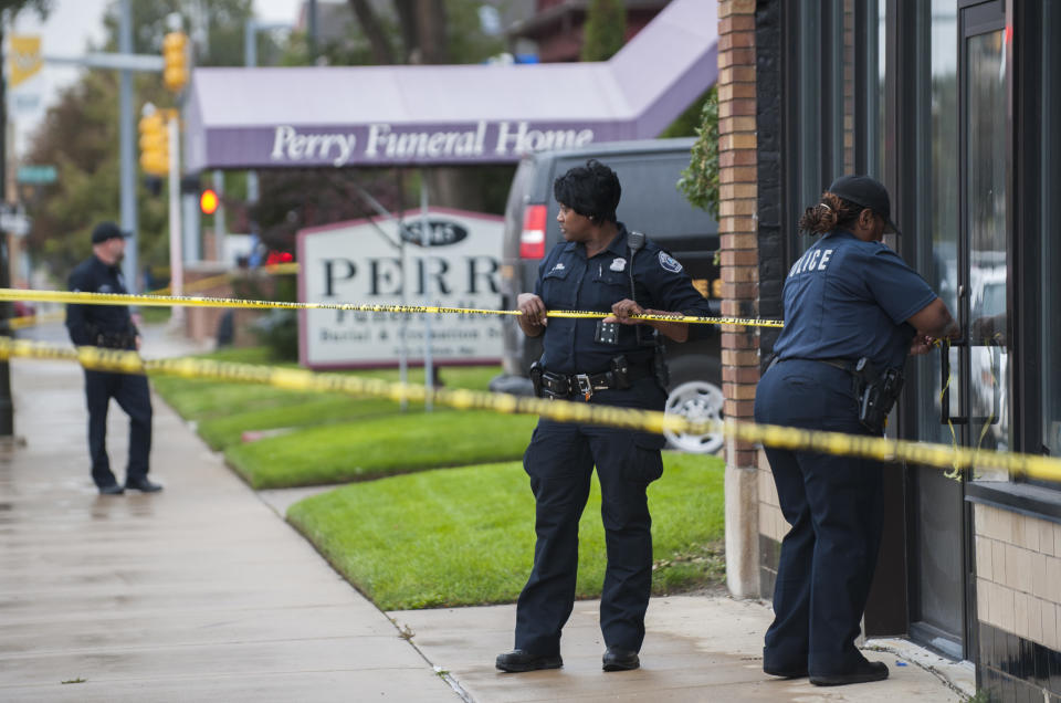 Detroit Police officers cordon off the area while they execute a search warrant at the Perry Funeral Home. Image: AP