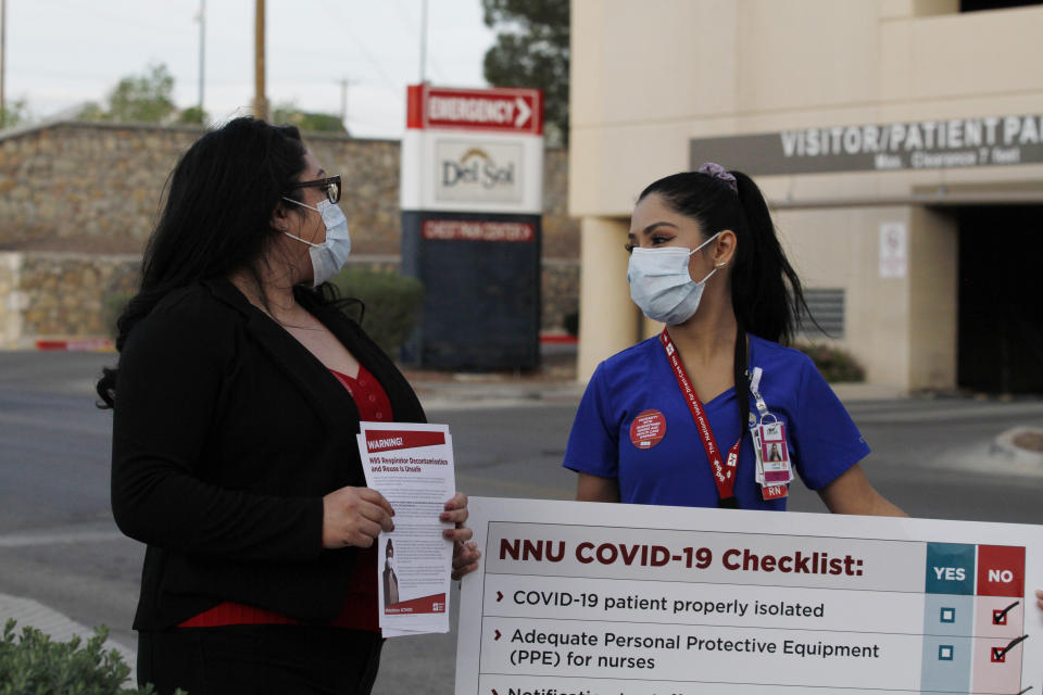 Nurses Tishna Soto, left, and Lizette Torres speak to reporters as they prepare a protest outside their work at the Las Palmas Del Sol Medical Center, Wednesday, April 1, 2020, in El Paso, Texas. Torres and Soto are members of National Nurses United, and were joined in calling for increased transparency and safety measures by members in other states. Tensions are running high at U.S. hospitals as medical systems in New York, Washington and Louisiana are shouldering an influx of patients with COVID-19 and workers lack protective gear. (AP Photo/Cedar Attanasio)