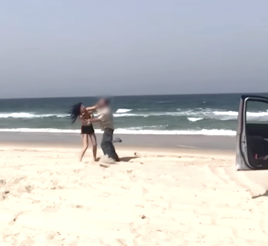 The woman can be seen striking one of the rangers on the beach on Bribie Island. 