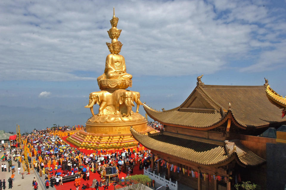 In this photo taken June 18, 2006, worshippers attend a ceremony at the Jin Ding, or Golden Tip, on Emei Mountains in Emeishan city in southwest China's Sichuan province. Authorities announced Monday, Oct. 22, 2012, a ban on temples selling shares to investors after leaders of several temples planned to pursue stock market listings for them as commercial entities. (AP Photo) CHINA OUT