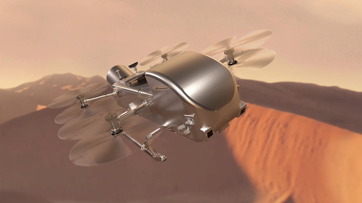  Illustration of a silvery metallic rotorcraft flying over orangish dunes. 