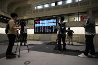 Members of media film the blank stock board at Tokyo Stock Exchange Thursday, Oct. 1, 2020, in Tokyo. The Tokyo Stock Exchange temporarily suspended all trading due to system problem. (AP Photo/Eugene Hoshiko)