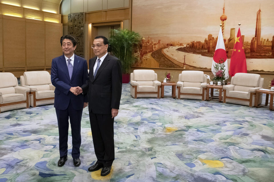 Chinese Premier Li Keqiang, right, and Japanese Prime Minister Shinzo Abe shake hands during their meeting at the Great Hall of the People in Beijing, Thursday, Oct. 25, 2018. Abe arrived in Beijing on Thursday as both countries try to repair ties that have been riven by disputes over territory, military expansion in the Pacific and World War II history. (Roman Pilipey/Pool Photo via AP)