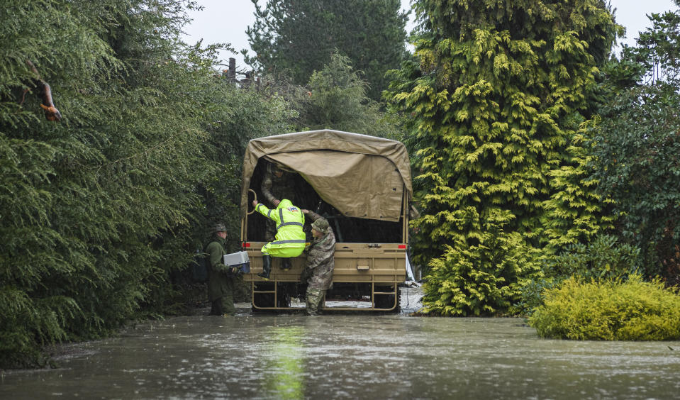 New Zealand Defense Force personnel assist a family with their evacuation near Ashburton in New Zealand's South Island, Sunday May 30, 2021. Several hundred people in New Zealand were evacuated from their homes Monday, May 31, 2021, as heavy rainfall caused flooding in the Canterbury region. (Corp. Sean Spivey/NZDF via AP)