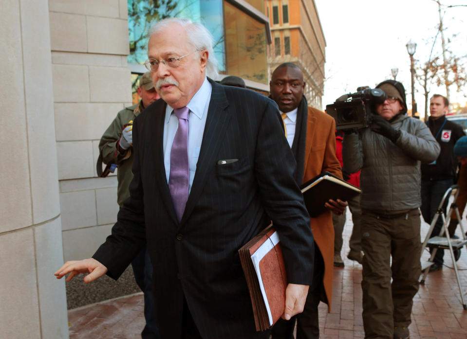 FILE - In this Nov. 13, 2014, file photo, pathologist Dr. Michael Baden, front, waves off media questions as he arrives to testify before the grand jury on the Michael Brown shooting in Clayton, Mo. Baden, who also testified for O.J. Simpson's defense in the "trial of the century" and helped investigate the assassinations of President John F. Kennedy and Dr. Martin Luther King Jr. is now enmeshed in another high-stakes case. Baden is the private pathologist who observed Jeffrey Epstein's autopsy on his lawyers' behalf. (Robert Cohen/St. Louis Post-Dispatch via AP, File)