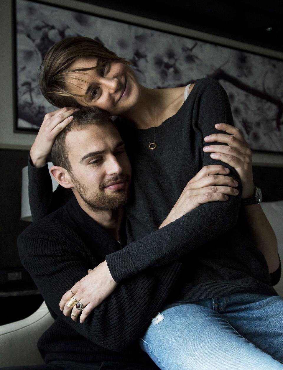 In this Thursday, March 6, 2014 file photo, actors Theo James, left, and Shailene Woodley pose for a photograph as they promote the movie "Divergent," in Toronto. The 22-year-old “Divergent” star gives hearty embraces often more than one - to everyone she meets. Woodley and James star in the anticipated first film in the young adult trilogy by author Veronica Roth. (AP Photo/The Canadian Press, Nathan Denette, file)