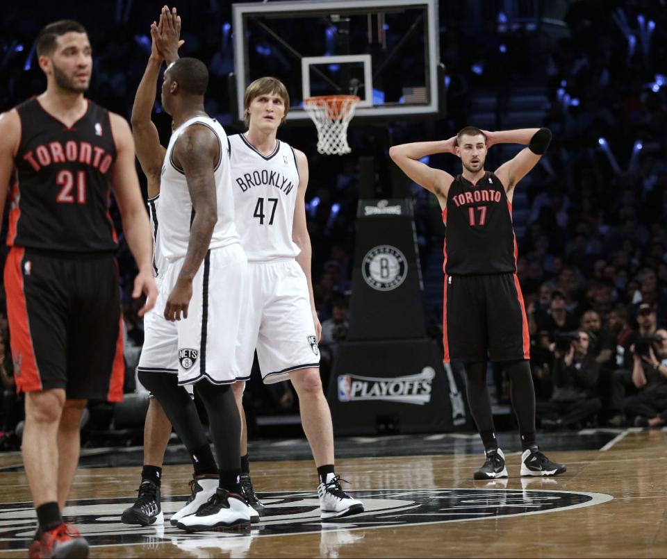 Toronto Raptors' Jonas Valanciunas (17) and Greivis Vasquez (21) react as Brooklyn Nets' Andray Blatche (0) and Andrei Kirilenko (47) celebrate with teammates during the second half of Game 3 of an NBA basketball first-round playoff series Friday, April 25, 2014, in New York. The Nets won 102-98. (AP Photo/Frank Franklin II)