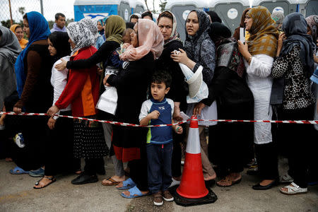 Migrants line up to receive personal hygiene goods distributed by the United Nations High Commissioner for Refugees (UNHCR), outside the main building of the disused Hellenikon airport where stranded refugees and migrants, most of them Afghans, are temporarily accommodated in Athens, Greece, May 3, 2016. REUTERS/Alkis Konstantinidis