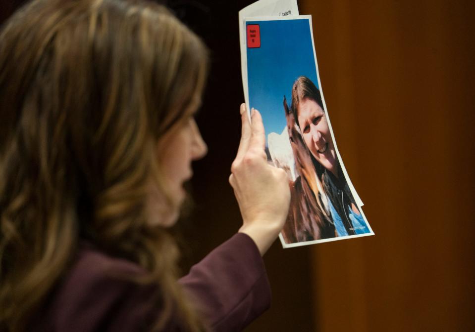 Shannon Smith, left, attorney for Jennifer Crumbley, holds up a photo of Crumbley with one of her horses during testimony in the Oakland County courtroom of Judge Cheryl Matthews on Thursday, Feb. 1, 2024.