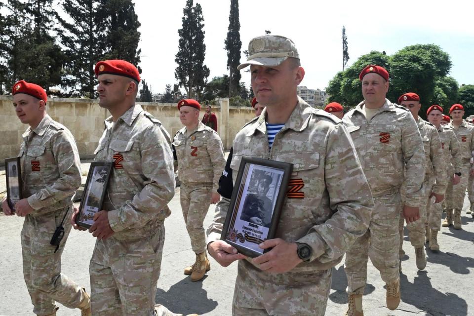 Russian military personnel, wearing a symbol “Z” in the colours of the Saint George ribbon, march during the Victory Day parade in Aleppo on 9 May (AFP via Getty Images)