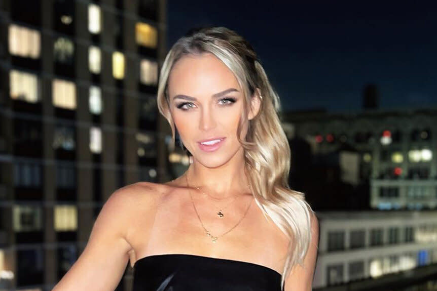 Olivia Flowers posing in a black outfit on a rooftop in New York City.