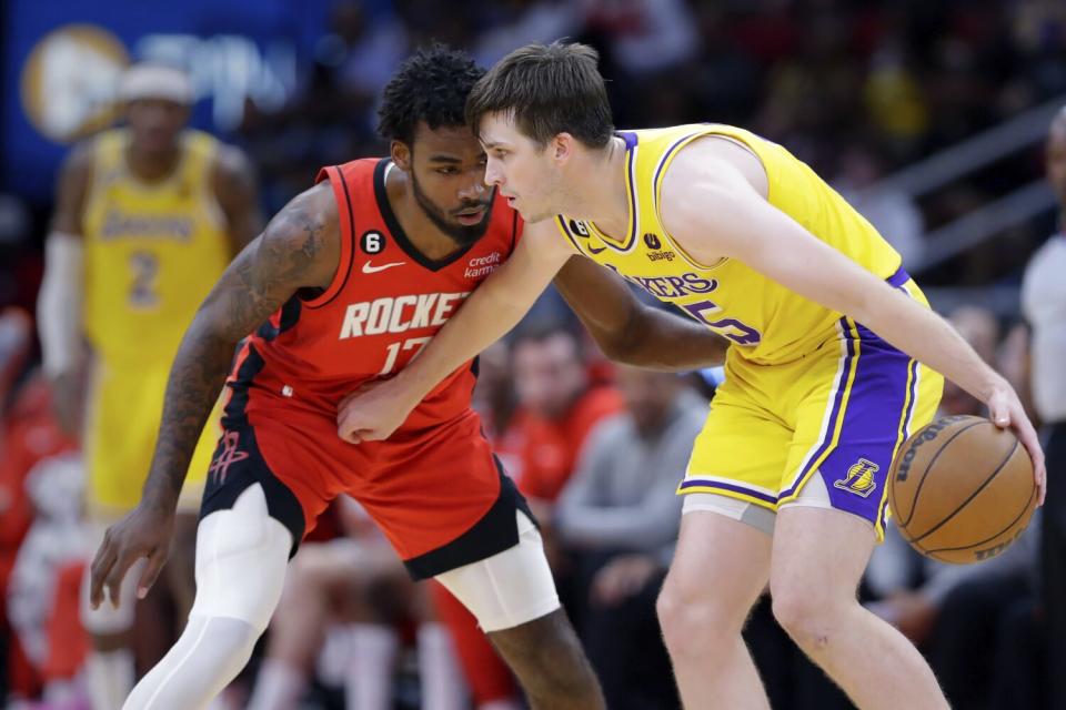 Lakers guard Austin Reaves attempts to drive around Houston Rockets forward Tari Eason.