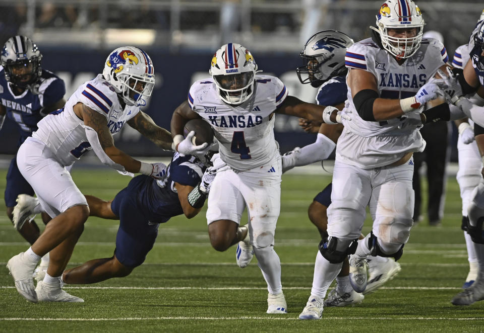 Kansas' Devin Neal avoids being tackled by Nevada's Ezekiel Robbins as he carries the ball in 4th quarter of an NCAA college football game Saturday, Sept. 16, 2023, in Reno, Nev. (AP Photo/Andy Barron)