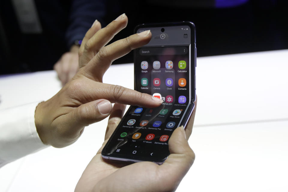 FILE - A Samsung worker gives a demonstration of the Galaxy Z Flip Phone at the Unpacked 2020 event in San Francisco, Tuesday, Feb. 11, 2020. Adult Happy Meals, and Galaxy flip phones are just some of the ways companies are putting a modern spin on nostalgia to resonate with consumers. While some businesses are content just rolling out nostalgic goods with few, if any, changes to them, other companies are threading the needle - successfully finding ways to bring nostalgic goods up to date to current times. (AP Photo/Jeff Chiu, File)