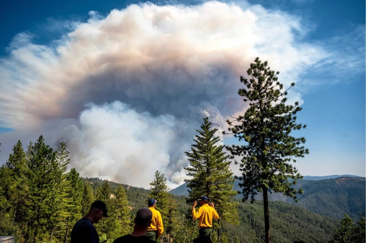 Firefighters in Placer County watch as a plume rises from the Mosquito Fire on Sept. 8, 2022.