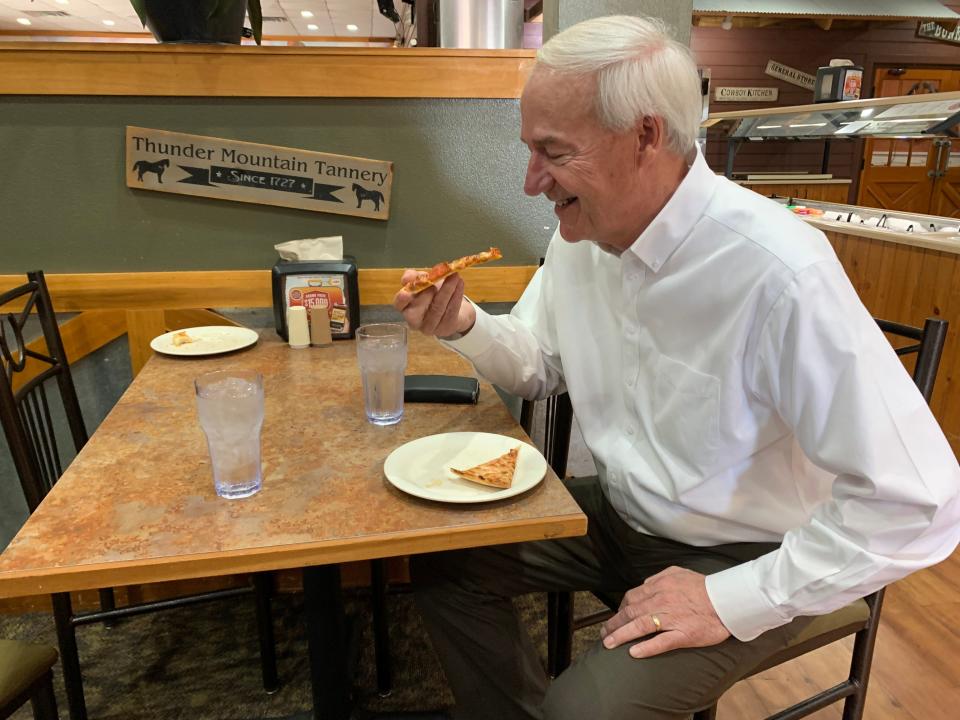 Republican presidential candidate and former Arkansas Governor Asa Hutchinson poses with a pepperoni pizza during his first visit to Iowa caucus staple, Pizza Ranch, in Newton, Iowa on July 11, 2023.