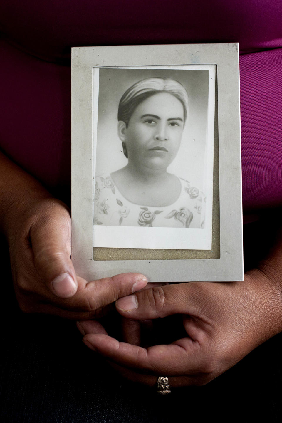 FILE - In this March 12, 2012 file photo, Felicita Romero holds an image of her mother Natividad Ramirez, a victim of the Dos Erres massacre, as she attends the trial of Pedro Pimentel Rios a former member of an elite Guatemalan military force known as the "kaibiles," at a court in Guatemala City. Jorge Sosa, a former Guatemalan army second lieutenant of the "kaibiles", suspected of participating in the killing at least 160 people in the Dos Erres village more than three decades ago, was sentenced in an American court on Monday, to up to a decade in prison for lying on his U.S. citizenship papers about his alleged role in the slayings. (AP Photo/Moises Castillo, File)