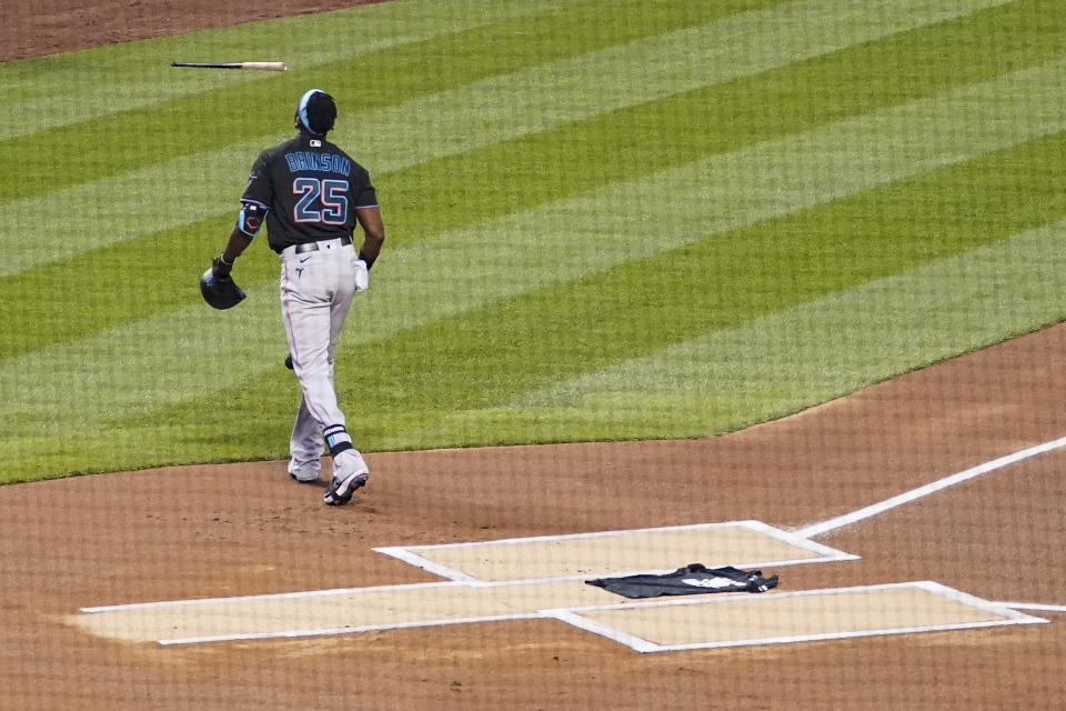 Miami Marlins center fielder Lewis Brinson (25) walks away from home plate after placing a Black Lives Matter shirt on home plate as teammates and the New York Mets walk off the field at the start of their baseball game, Thursday, Aug. 27, 2020, in New York. The teams jointly walked off the field after a moment of silence, draping the shirt across the plate as they chose not to start their scheduled game Thursday night. (AP Photo/John Minchillo)