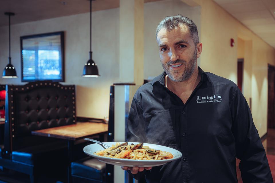Vito Morino, owner of Luigi's Restaurant, holds a steaming plate of Fettuccini Tutto Mare.