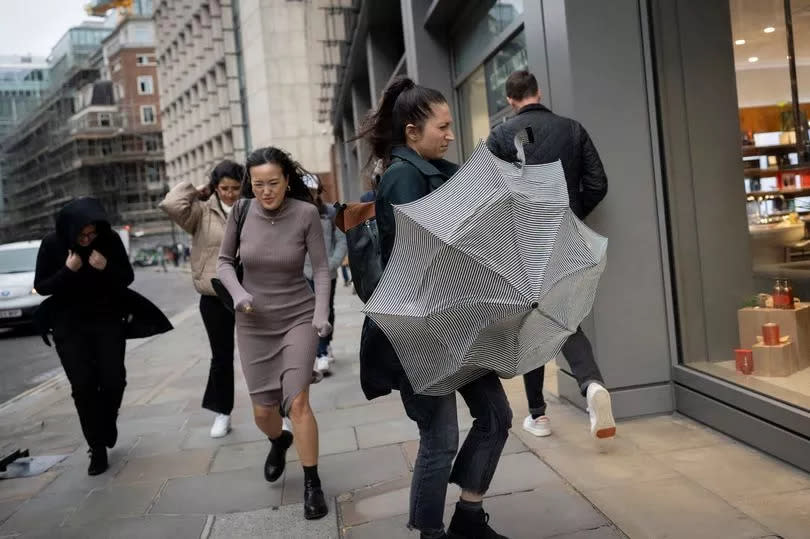 Pedestrians cope with strong winds during Storm Ciaran in November 2023